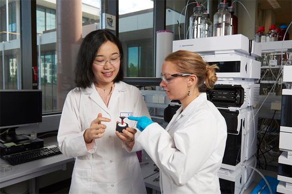 Two scientists in the lab in front of an Agilent Infinity II LC System