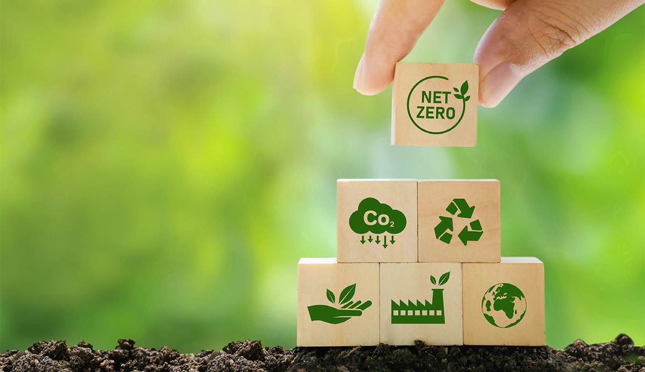 Hand stacking wooden blocks with environmental symbols on them