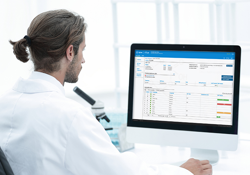 Lab scientist on laptop with Agilent CrossLab Smart Alerts on screen