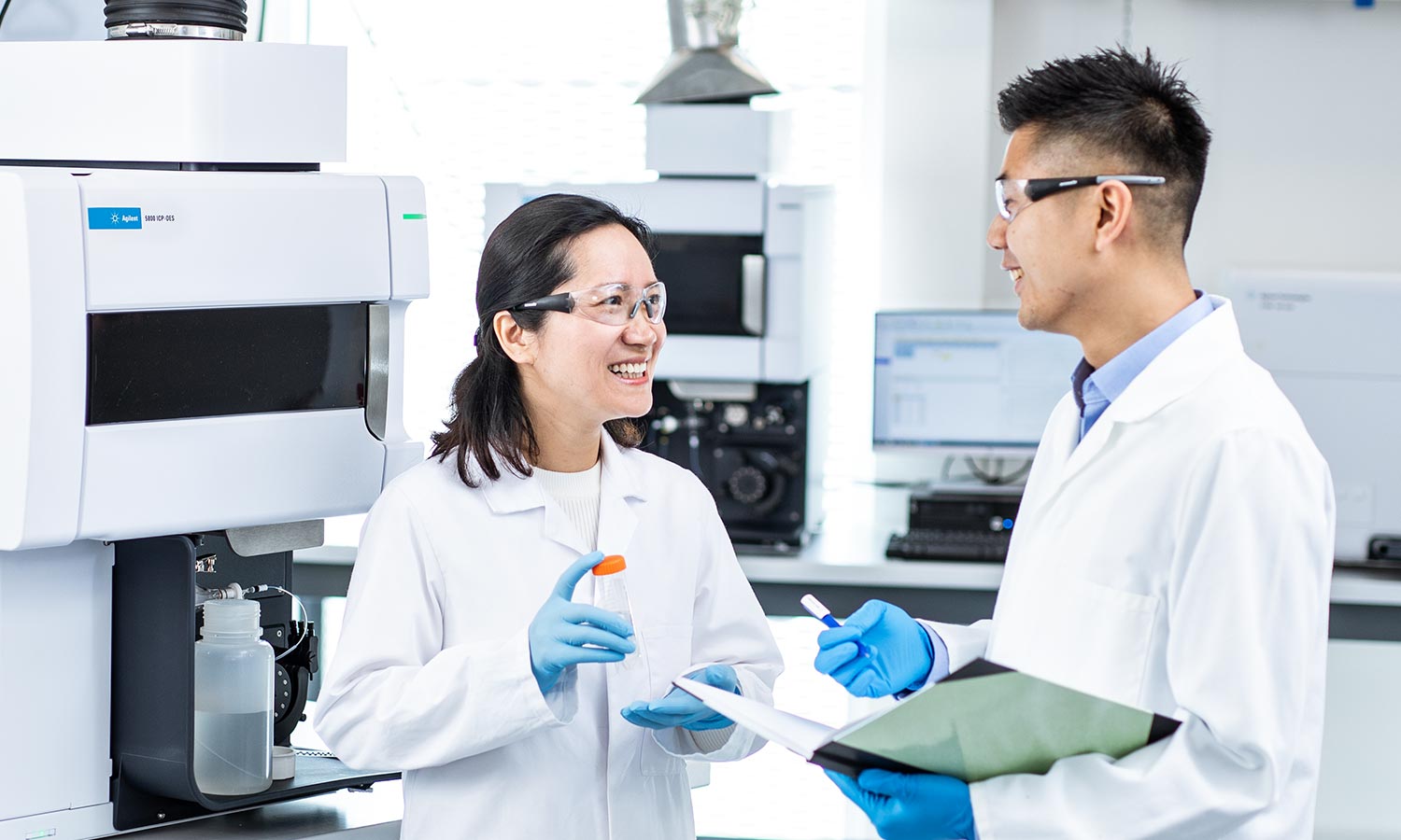 Two lab technicians working in a lab with Agilent instruments