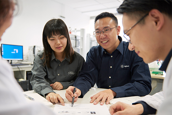 A woman and man talking to another man around a table
