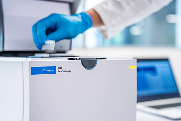 Lab technician loading a tube strip into the Agilent 4150 TapeStationDx system.